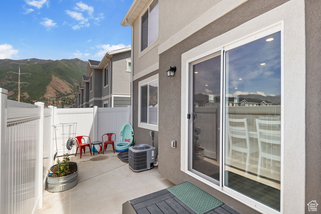 Fenced backyard with a patio area, cooling unit, and a mountain view