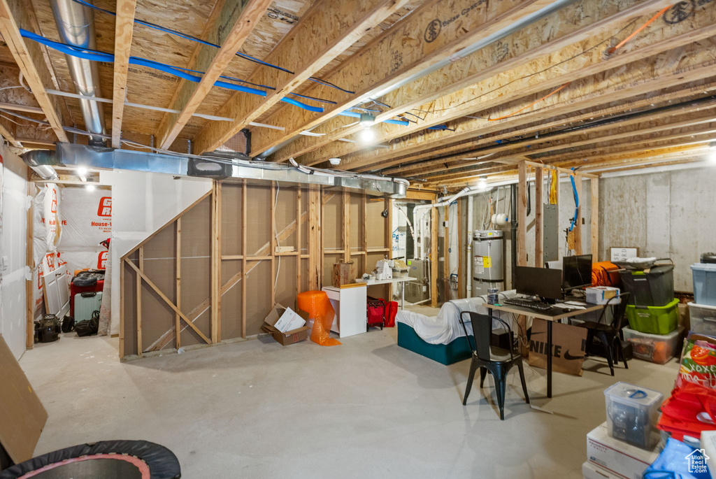Unfinished below grade area featuring electric panel and water heater