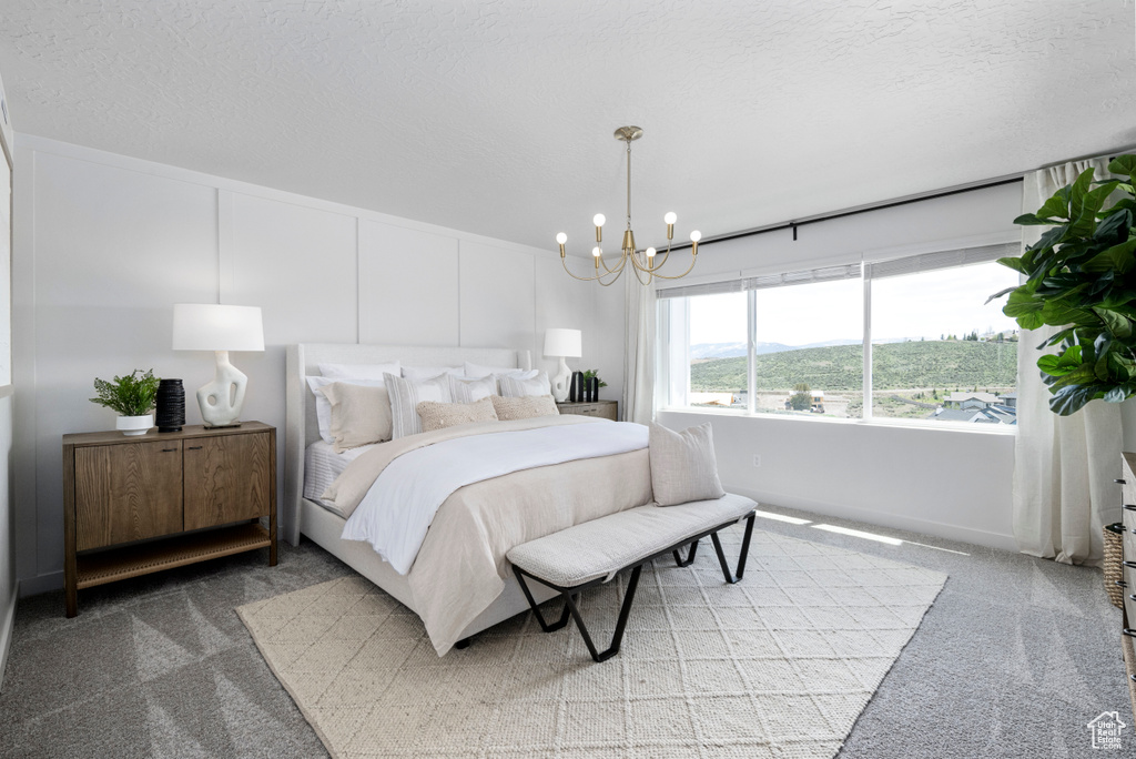 Bedroom with light carpet, a chandelier, and a textured ceiling