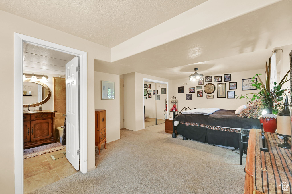 Bedroom with light colored carpet and connected bathroom