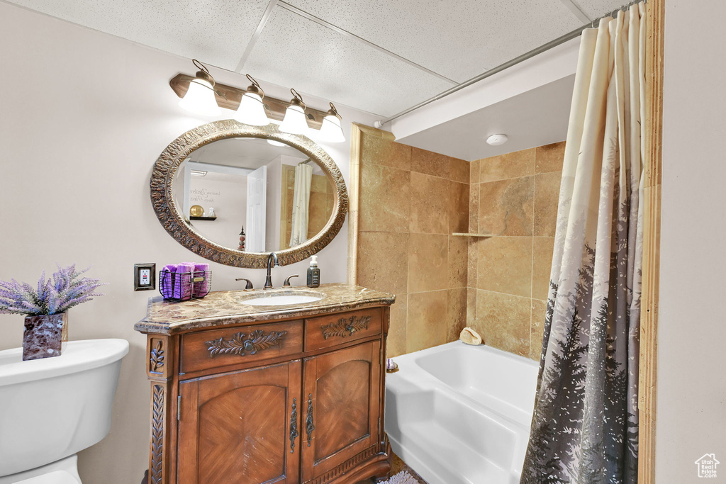 Bathroom with toilet, vanity, and shower / bath combo with shower curtain