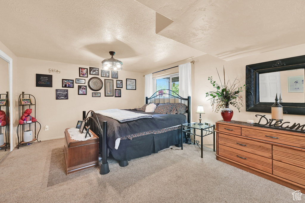 Carpeted bedroom with a textured ceiling and baseboards