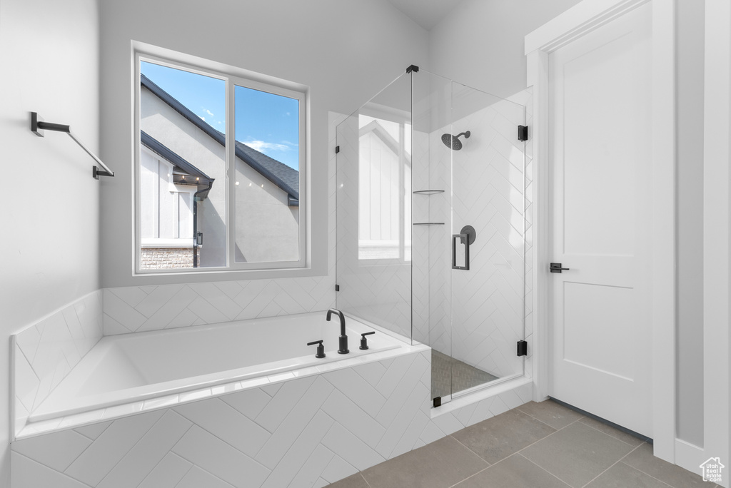 Full bath with a bath, a shower stall, healthy amount of natural light, and tile patterned flooring