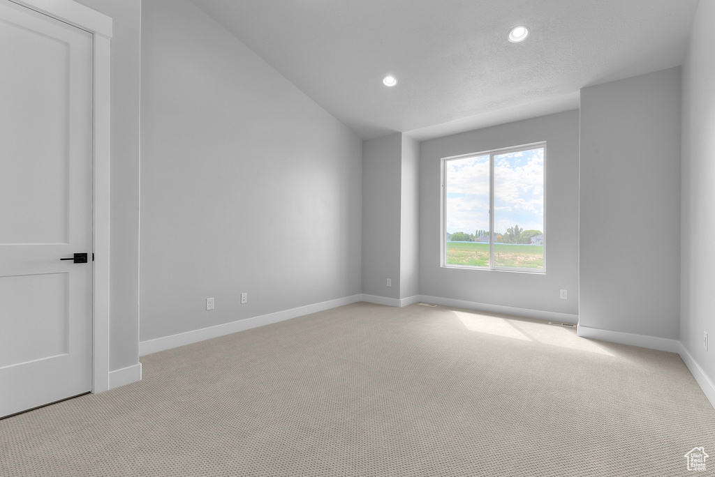 Unfurnished room with light carpet, recessed lighting, baseboards, and vaulted ceiling