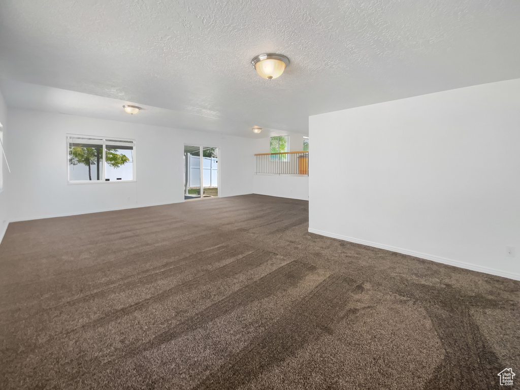 Empty room with carpet floors and a textured ceiling