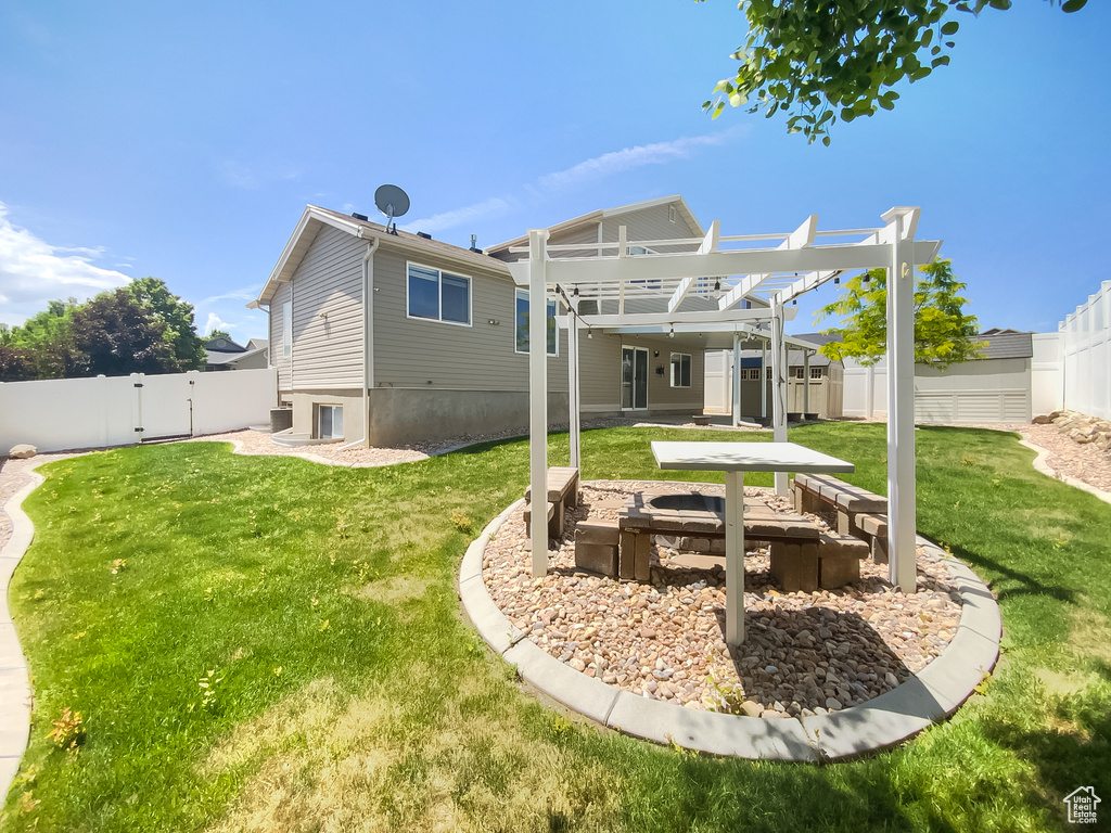 Rear view of house with a pergola, a fire pit, and a gate