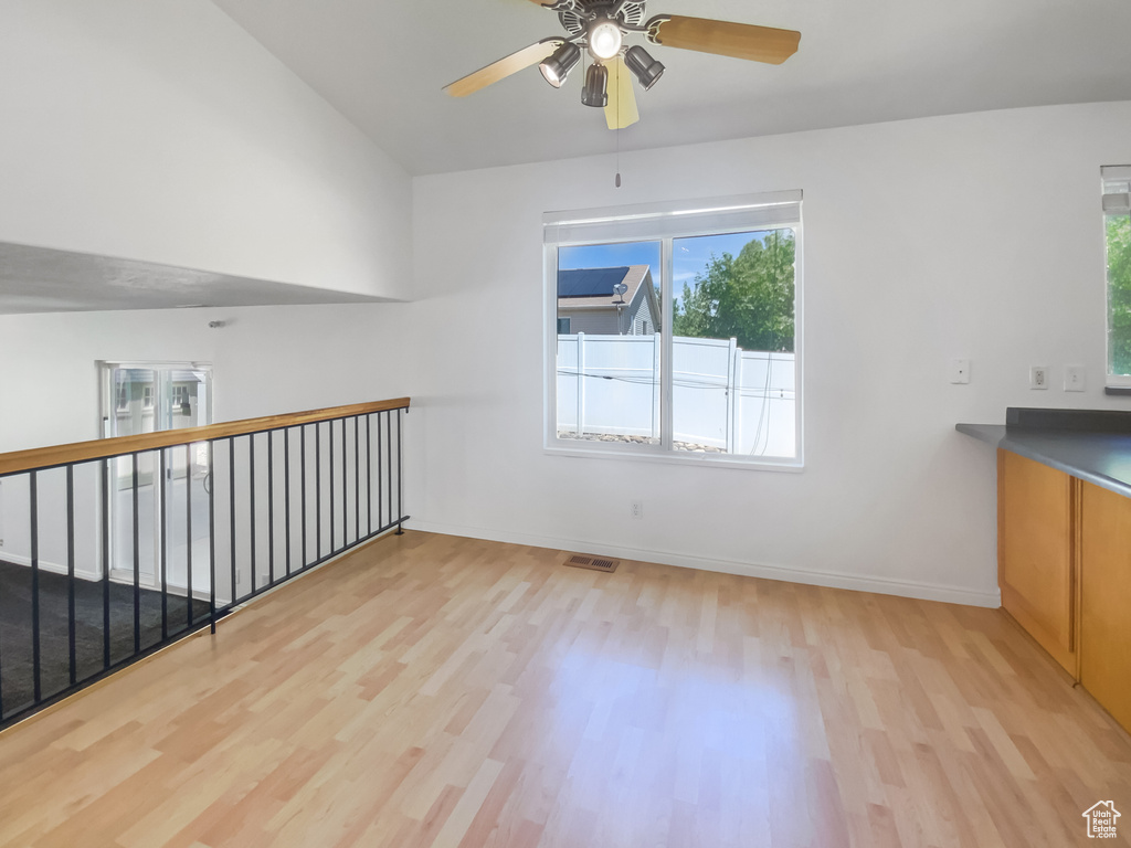 Unfurnished room with light wood finished floors, ceiling fan, and baseboards