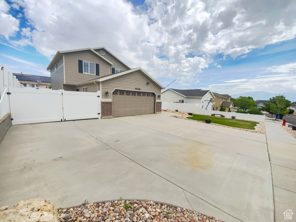 View of property exterior featuring concrete driveway, a garage, and brick siding