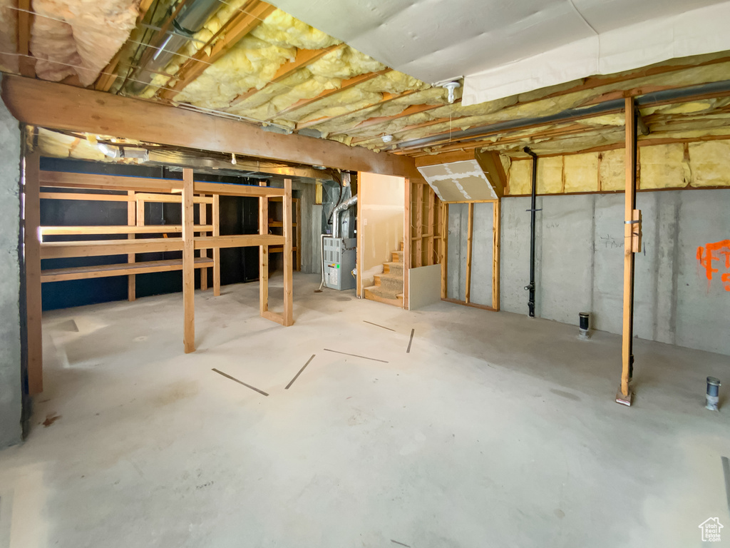 Unfinished below grade area with stairway and heating unit