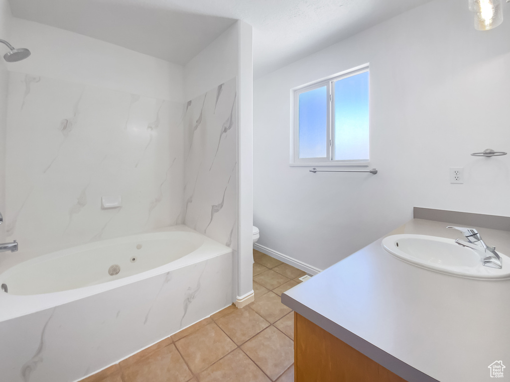 Full bath with vanity, toilet, tile patterned floors, a combined bath / shower with marble appearance, and baseboards