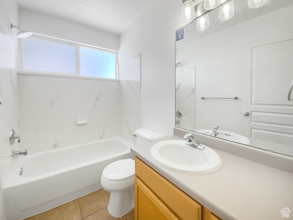 Bathroom featuring vanity, toilet, tile patterned floors, and shower / washtub combination
