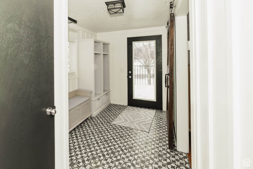 Mudroom featuring a textured ceiling