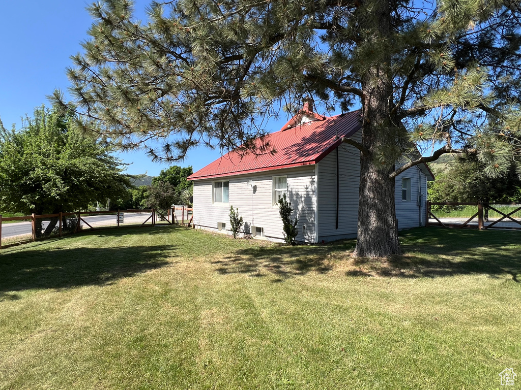 Rear view of property with a chimney and metal roof
