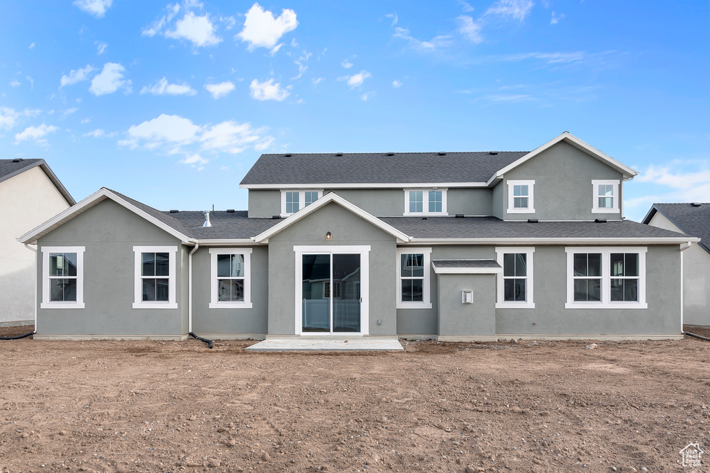 Back of house with stucco siding and a patio area