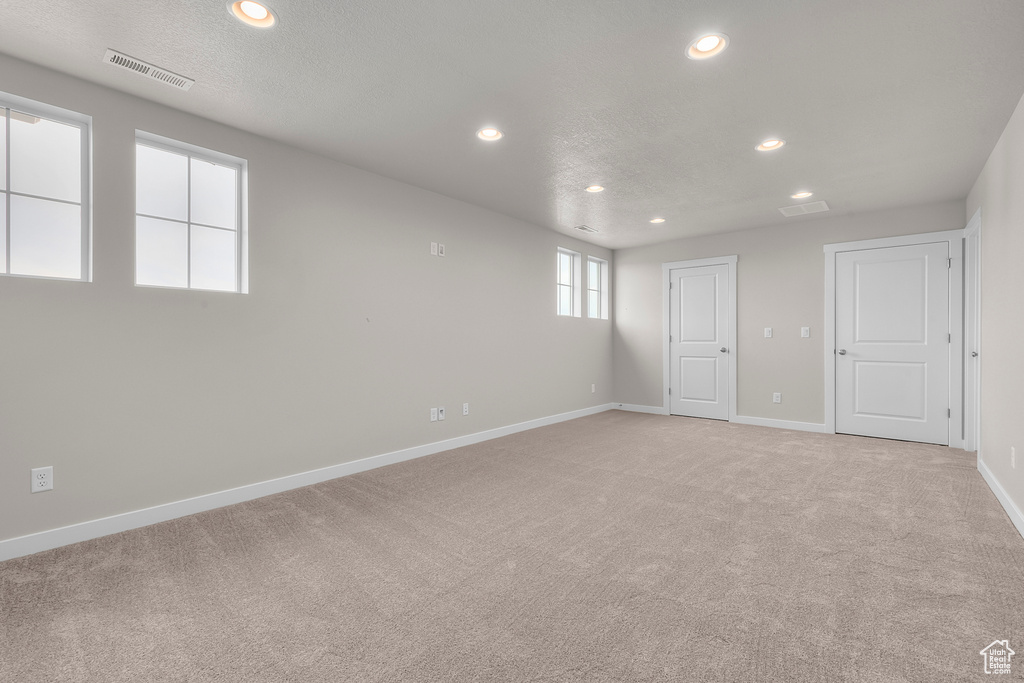 Spare room featuring recessed lighting, light colored carpet, and baseboards