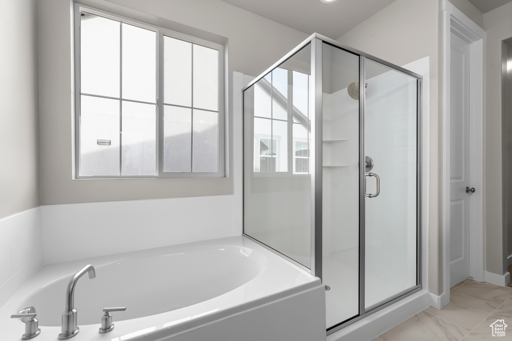 Full bathroom with a stall shower, a bath, and marble finish flooring