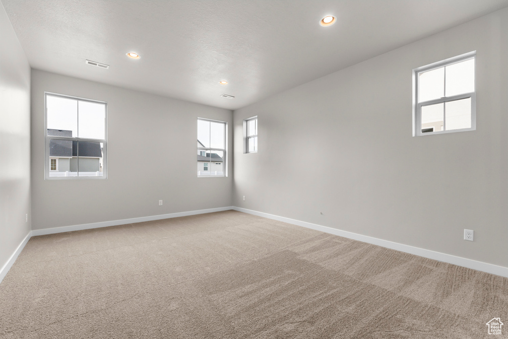 Unfurnished room featuring light carpet, baseboards, and recessed lighting