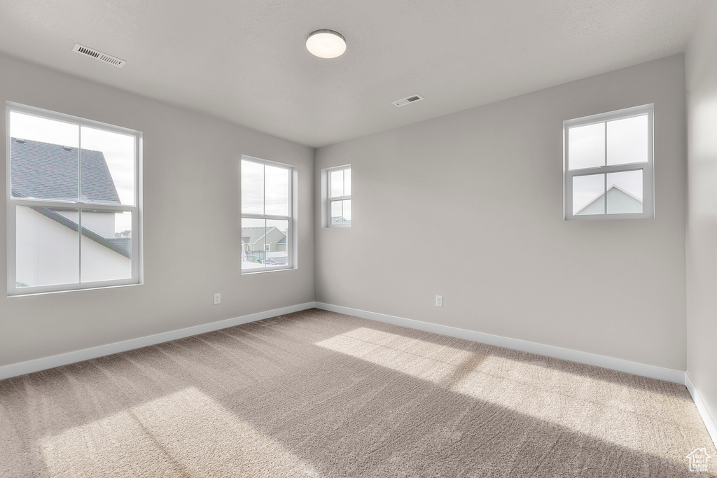 Spare room featuring carpet floors and baseboards