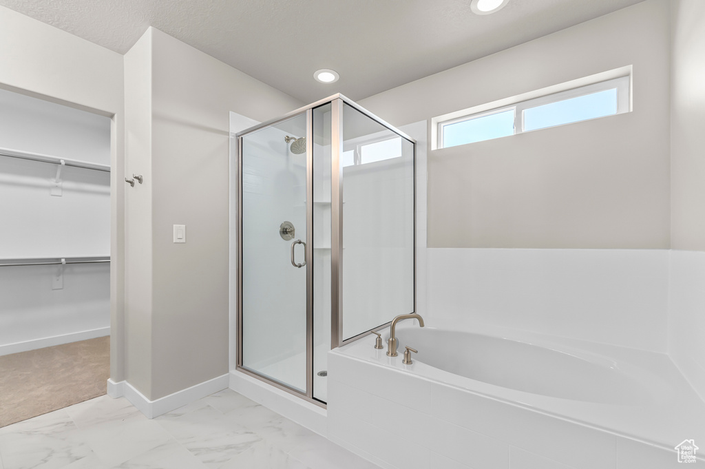 Full bathroom with a stall shower, a garden tub, a spacious closet, marble finish floors, and recessed lighting