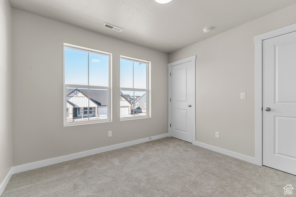 Unfurnished bedroom with carpet flooring, baseboards, and a textured ceiling