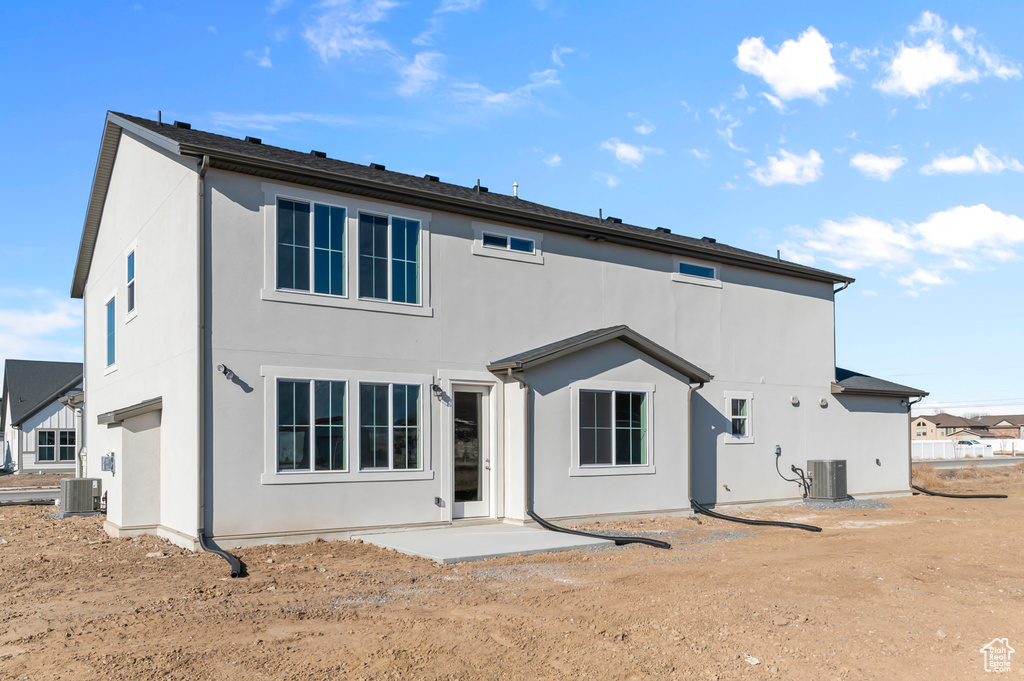 Back of house with cooling unit and stucco siding