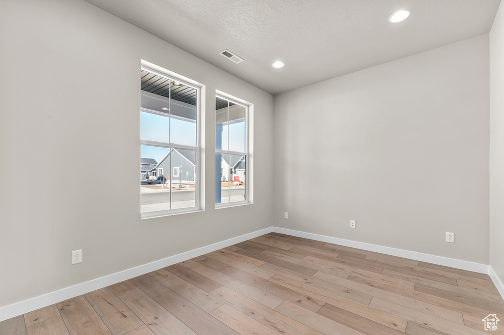 Unfurnished room featuring light wood-type flooring, baseboards, and recessed lighting