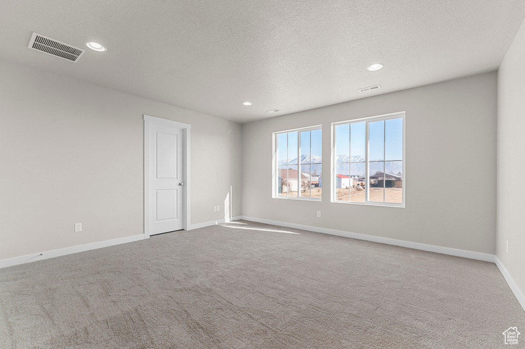 Carpeted empty room featuring recessed lighting and baseboards