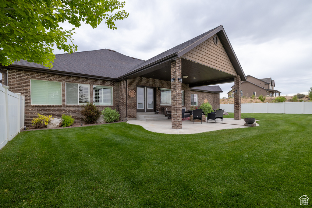 Back of property with brick siding, a patio area, a shingled roof, and entry steps