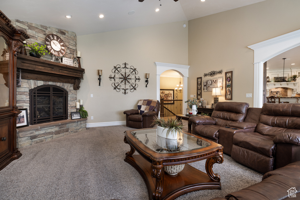 Carpeted living room featuring a fireplace, a towering ceiling, recessed lighting, and baseboards