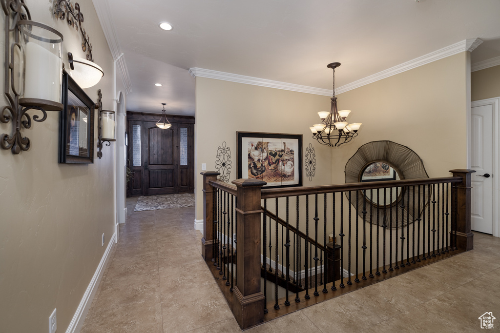 Hall with an upstairs landing, baseboards, ornamental molding, a chandelier, and recessed lighting