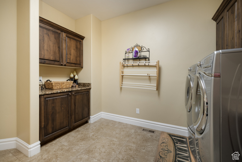 Laundry area featuring cabinet space, baseboards, and separate washer and dryer