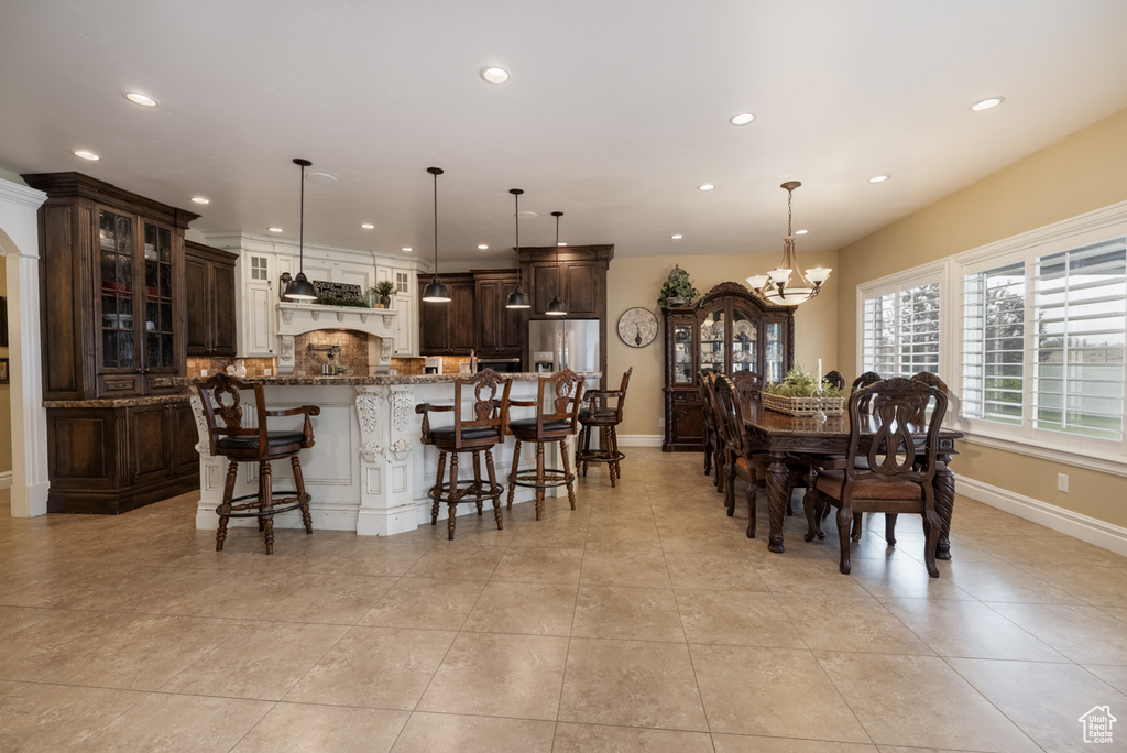 Dining area featuring a chandelier, recessed lighting, baseboards, and light tile patterned flooring