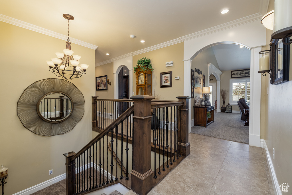 Staircase with arched walkways, baseboards, a chandelier, recessed lighting, and carpet flooring
