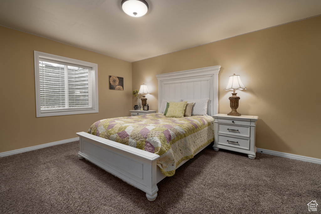 Bedroom featuring dark carpet and baseboards