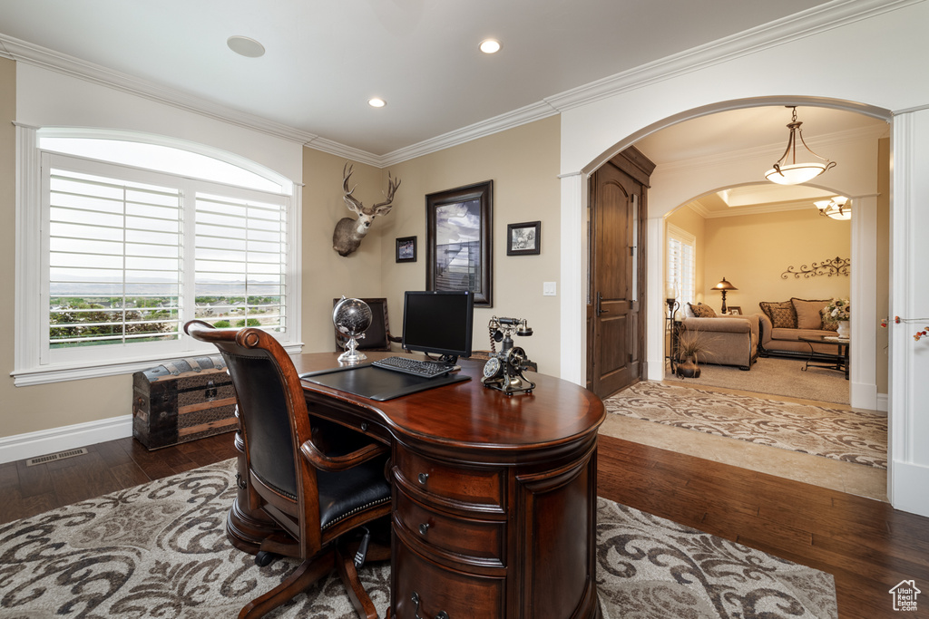Office space with wood finished floors, arched walkways, ornamental molding, recessed lighting, and baseboards
