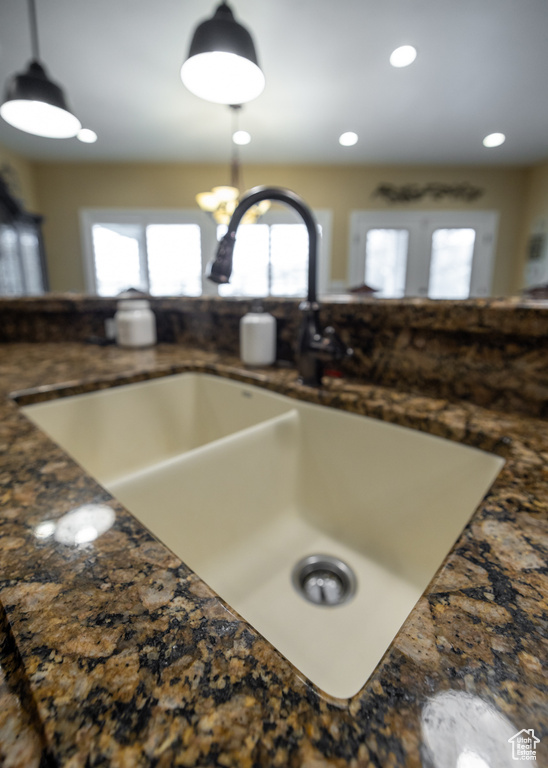 Kitchen view of a sink, hanging light fixtures, dark countertops, and recessed lighting