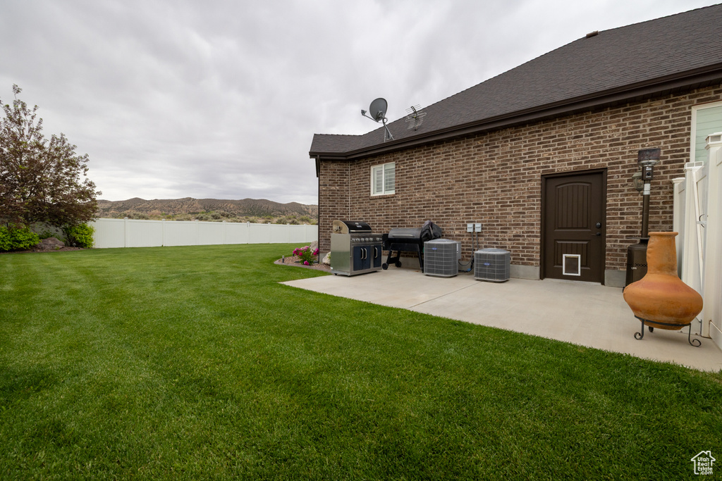 View of yard with a patio and central AC unit