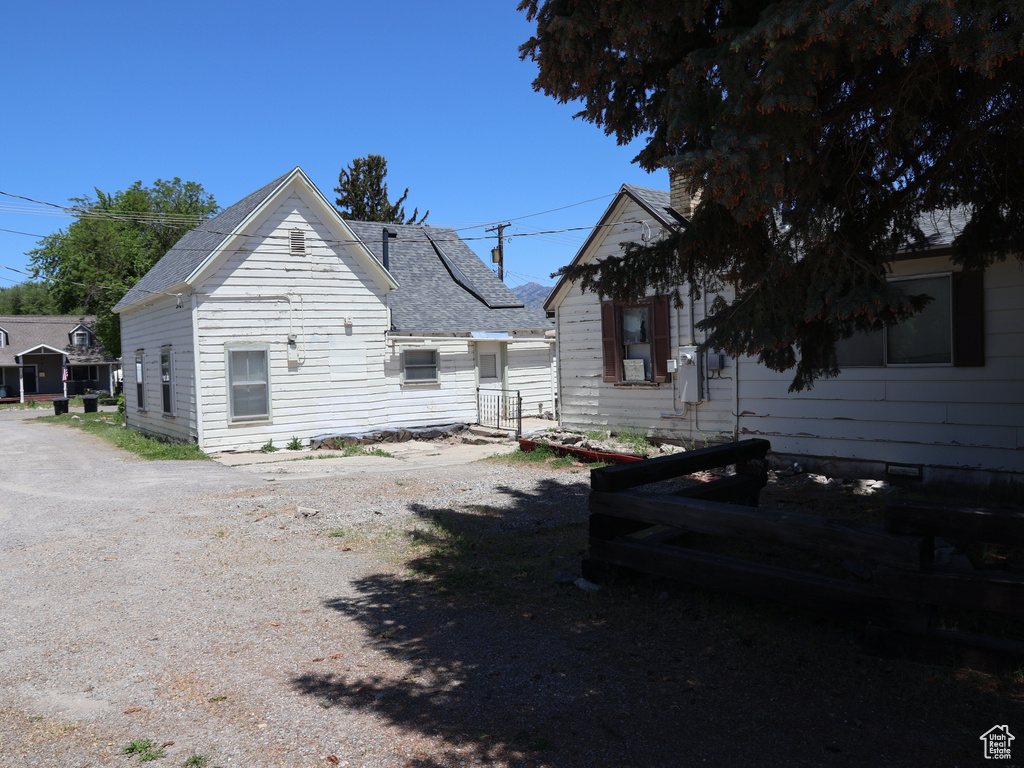 Back of property featuring roof with shingles