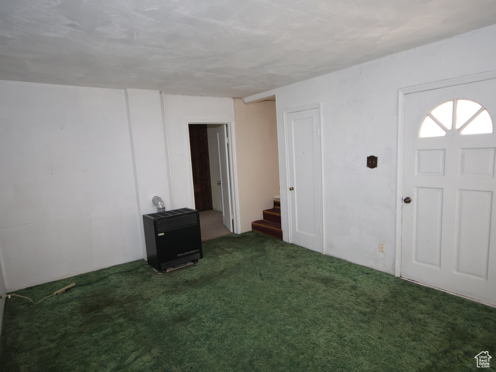 Entrance foyer with stairway, heating unit, and carpet floors