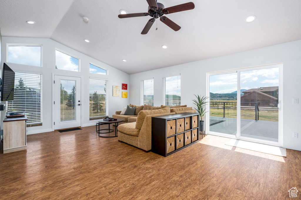 Living room featuring lofted ceiling, wood finished floors, healthy amount of natural light, ceiling fan, and recessed lighting