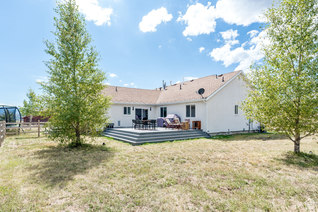 Back of property with a wooden deck and stucco siding