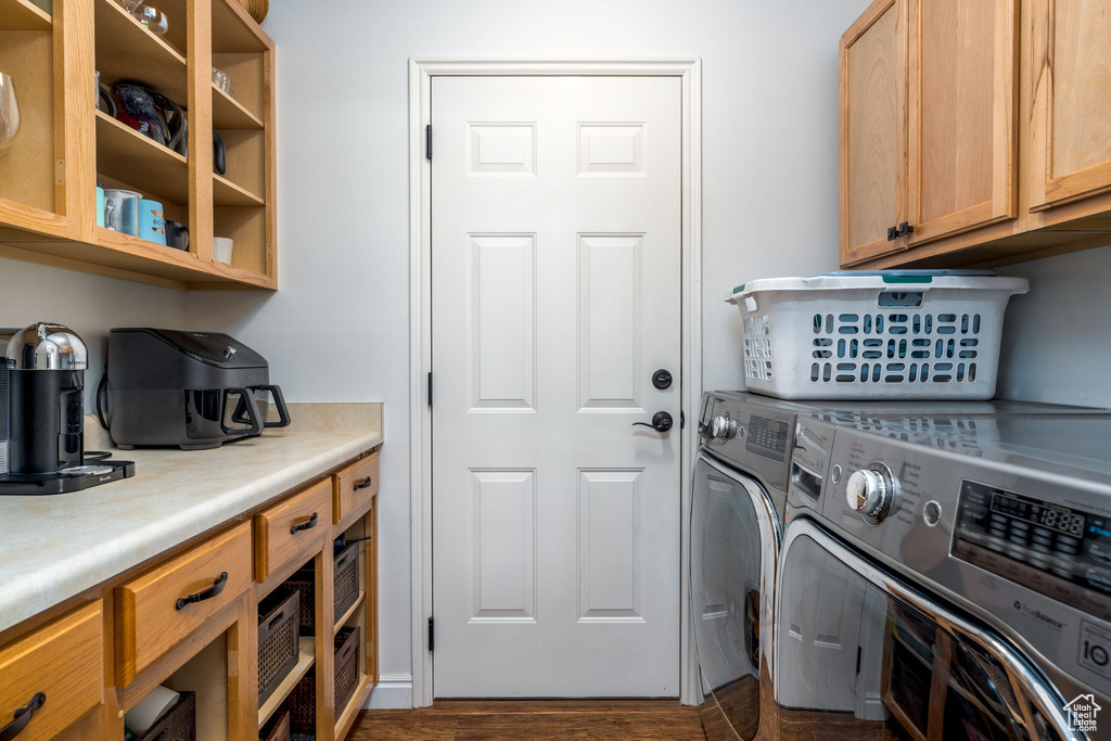 Laundry room featuring independent washer and dryer, cabinet space, and dark wood-style flooring