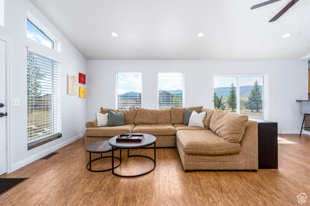 Living area featuring light wood-style floors, ceiling fan, baseboards, and recessed lighting