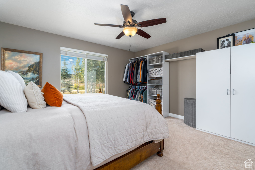 Bedroom with light carpet and ceiling fan