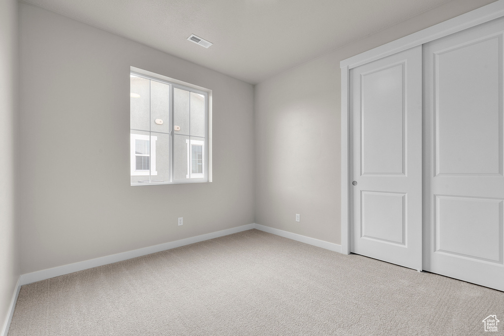 Unfurnished bedroom with carpet floors, baseboards, and a closet