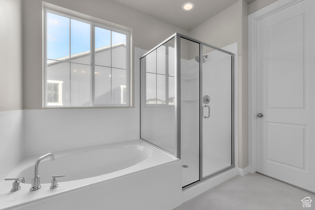 Full bathroom featuring a shower stall, a garden tub, and tile patterned floors
