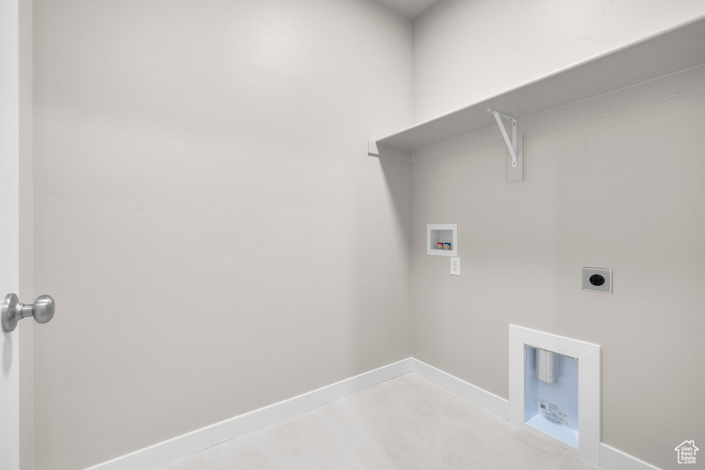 Washroom with hookup for a washing machine, hookup for an electric dryer, and baseboards