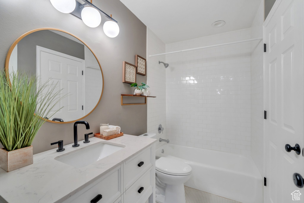 Bathroom featuring vanity, washtub / shower combination, toilet, and tile patterned flooring