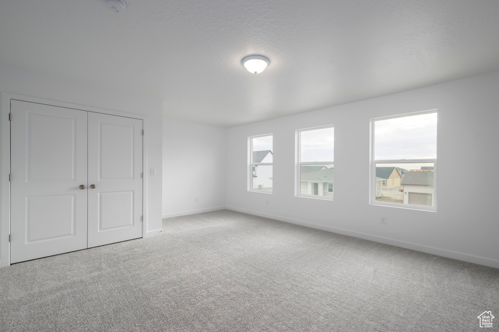 Unfurnished bedroom featuring carpet, baseboards, and a closet