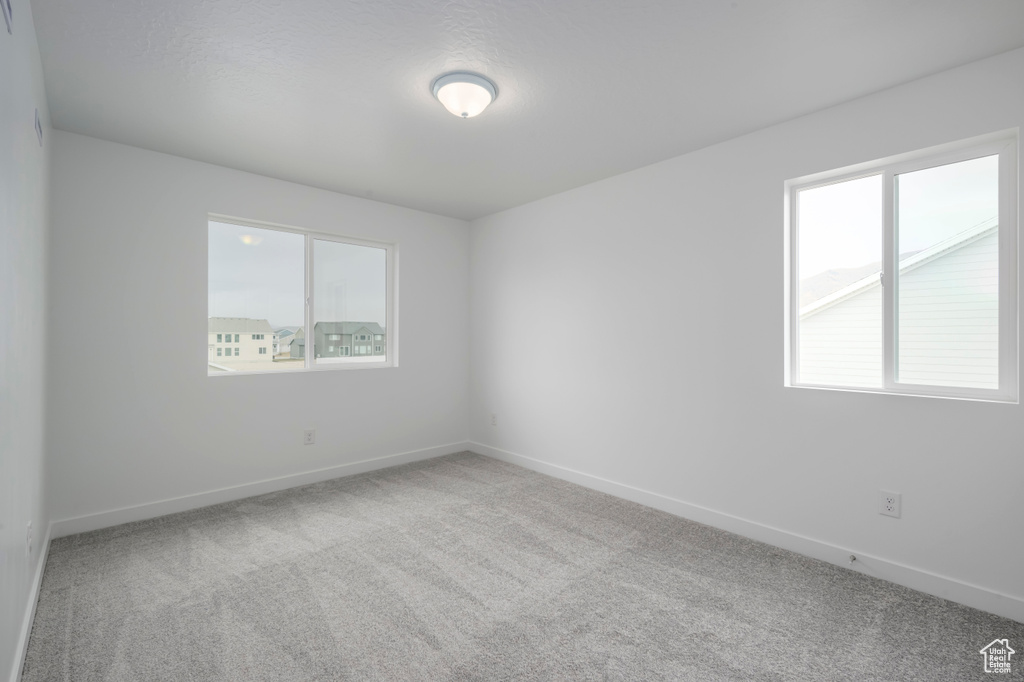 Carpeted empty room featuring baseboards